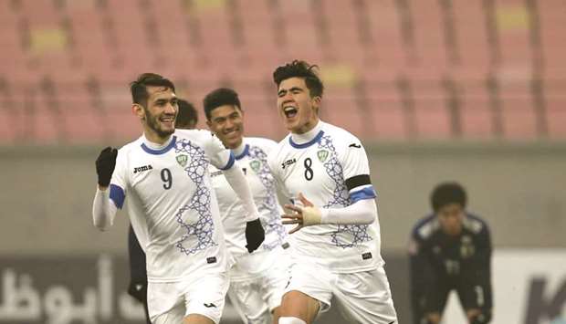 Uzbekistanu2019s Jasurbek Yakhshiboev (right) celebrates his goal with teammate during their match against Japan yesterday. (AFC)