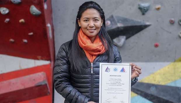 Nepali mountain guide Dawa Yangzum Sherpa posing with a mountaineering certificate in Kathmandu