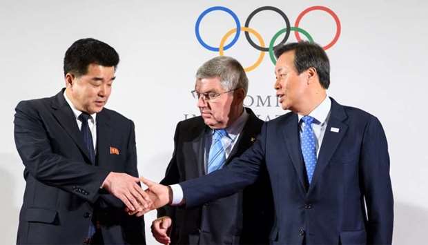 International Olympic Committee (IOC) President Thomas Bach (C) poses with North Korea's Sports Minister and Olympic Committee president Kim Il Guk (L) and South Korean Minister of Culture, Sports and Tourism Do Jong-hwan at the IOC headquarters
