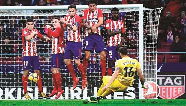 Atletico Madrid players jump to block a free kick by Gironau2019s David Timor during the Spanish league match in Madrid. (AFP)