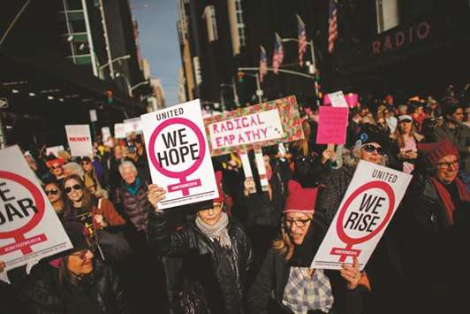 People hold up signs at a Womenu2019s March in New York City on Saturday.