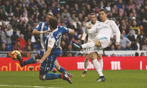 Real Madridu2019s Cristiano Ronaldo (right) shoots at goal during the La Liga match against Deportivo La Coruna at Santiago Bernabeu Stadium in Madrid, Spain, yesterday. (Reuters)