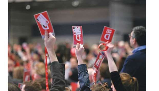 SPD delegates hold up their voting cards during the party congress in Bonn.