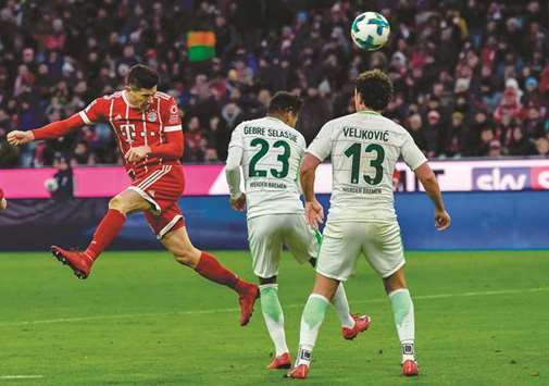 Bayern Munichu2019s Robert Lewandowski (left) heads the ball to score a goal against Weder Bremen during their Bundesliga match in Munich, Germany, yesterday. (AFP)