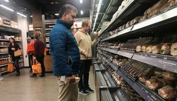 Customers browse packaged wraps, sandwiches and salads at Amazon's new ,grab-and-go, store in Seattle