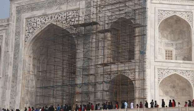 Tourists visiting the Taj Mahal near scaffolding installed for the conservation work at the monument in the Indian city of Agra.