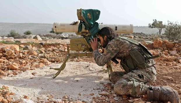 A Turkish-backed Syrian rebel fighter looks through the scope of a rocket launcher at a monitoring point near the Syrian village of Qilah, in the southwestern edge of the Afrin region close to the border with Turkey. AFP