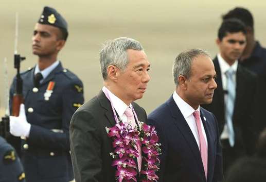 Sri Lankan Law and Order Minister Sagala Ratnayaka, right, accompanies Singapore Prime Minister Lee Hsien Loong, centre, during a welcoming ceremony at the Bandaranaike International airport in Katunayake, near Colombo, yesterday.