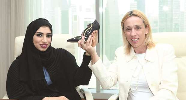 Qatari shoe designer Hissa al-Haddad and Italian Chamber of Commerce in Qatar chairperson Palma Libotte display one of the designs.