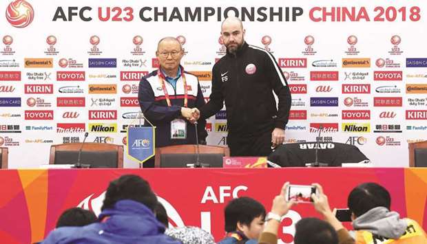Qatar coach Felix Sanchez and his Vietnam counterpart Park Hang-seo shake hands at their press conference yesterday. Picture on right shows Qatari players at a training session.