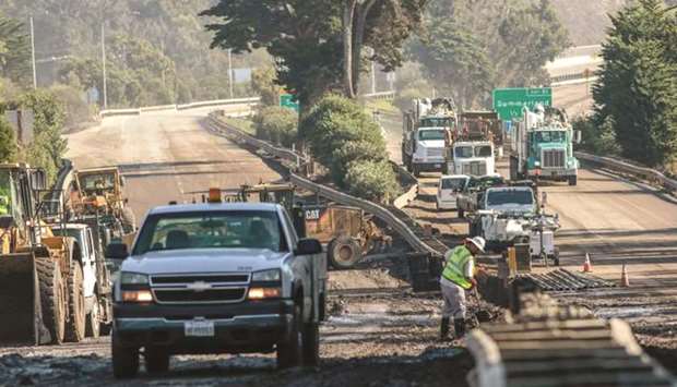 Workers clear mud and debris on on Highway 101 after a mudslide in Montecito, California.