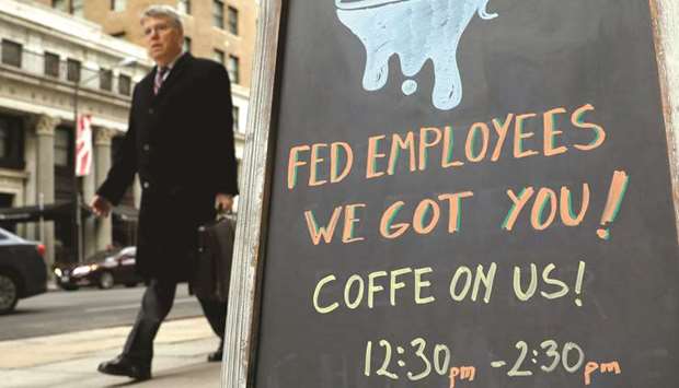 A worker passes a cafe offering free coffee to federal employees near the White House in Washington yesterday morning.