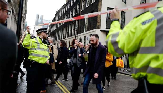Workers are evacuated from offices on a street adjoining The Strand in London on Tuesday.