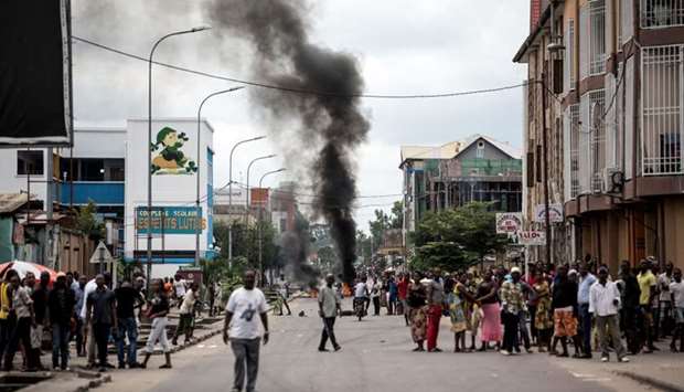 People look on as protesters burn tyres during a demonstration calling for the President of the Democratic Republic of the Congo (DRC)to step down on January 21, 2018 in Kinshasa.
