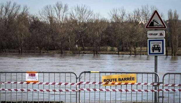Barriers with a sign reading ,road closed, are seen near the flooded banks of the Rhone river in Grigny.