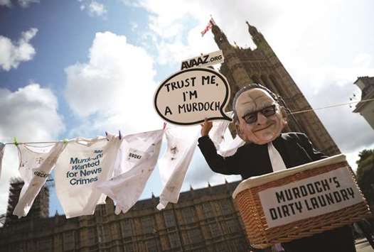 A protester depicting media magnate Rupert Murdoch demonstrates opposite the Houses of Parliament in London. Foxu2019s bid to buy the European pay-TV broadcaster Sky wouldnu2019t be in the public interest, the Competition and Markets Authority said in provisional findings yesterday.