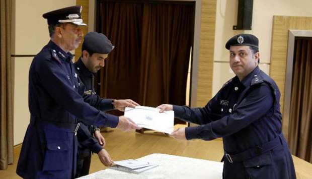 Director General of Public Security Saad bin Jassim al-Khulaifi gives away the certificate to an officer graduate.