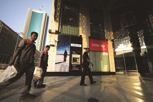 Workers pass by an HSBC Bank branch in downtown Manama (file). Any delay to the austerity drive could worry credit rating agencies, which already assess Bahrainu2019s sovereign debt as junk.