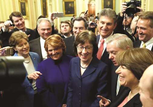 US Senator Susan Collins (R-ME) addresses reporters with as fellow Senators Jeanne Shaheen (D-NH), Tim Kaine (D-VA), Heidi Heitkamp (D-ND), Joe Manchin (D-WV), Lindsey Graham (R-SC), Amy Klobuchar (D-MN) and Jeff Flake (R-AZ) look on after lawmakers struck a deal to reopen the federal government three days into a shutdown on Capitol Hill in Washington on Monday.