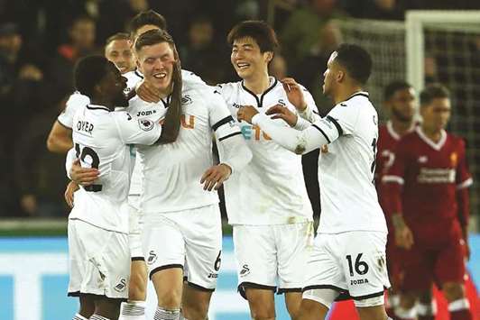 Swansea Cityu2019s Alfie Mawson (centre) celebrates with teammates after scoring against Liverpool in the Premier League on Monday night. ( AFP)