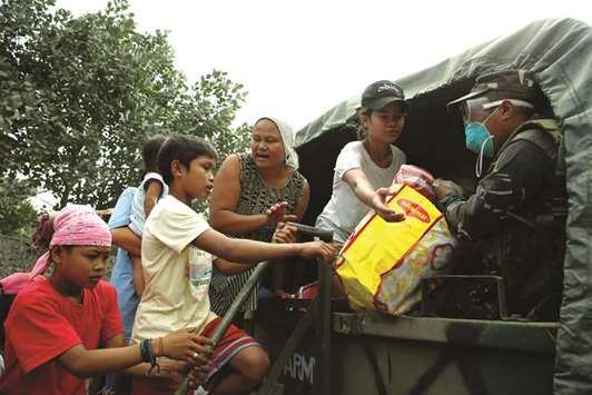 A soldier helps residents as they prepare to depart to an evacuation centre after the Mayon volcano erupted in Guniobatan, Albay Province, yesterday.