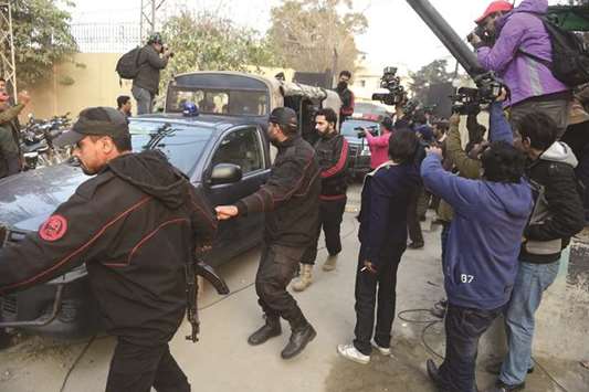 Policemen escort the van carrying a suspect accused of raping and murdering a young girl as they leave an anti-terrorist court in Lahore yesterday.