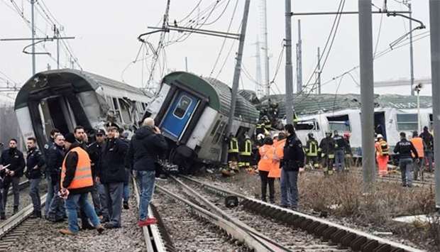 Rescue workers and police officers stand near derailed trains in Pioltello, on the outskirts of Milan, on Thursday.
