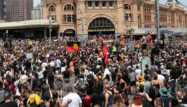 A large crowd of protesters take over the intersection in front of Flinders Street Station as part of an 'Invasion Day' rally in Melbourne on Friday.