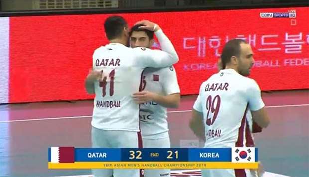 TV grab shows Qatar players embracing after their win against South Korea.