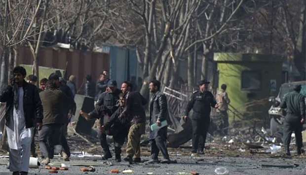 Afghan volunteers and policemen help wounded at the scene of a car bomb explosion in front of the old interior ministry building in Kabul on Saturday.