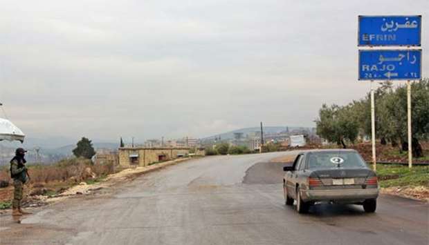 A member of the Kurdish People's Protection Units (YPG) militia stands guard at the entrance of the northern Syrian city of Afrin.