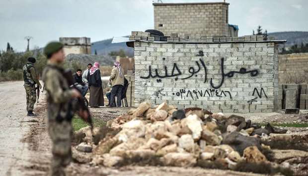 Turkish-backed Syrian rebel fighters man a checkpoint in the Syrian town of Azaz, on a road leading to Afrin, yesterday.