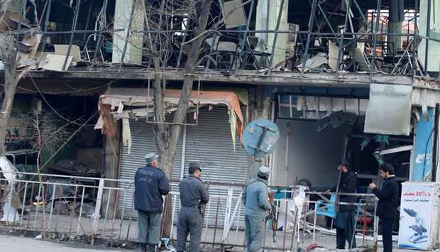 Afghan policemen inspect the site of a bomb attack in Kabul, Afghanistan