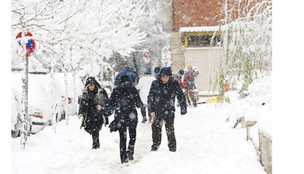 Iranians walk amid the snow in the capital Tehran, yesterday.