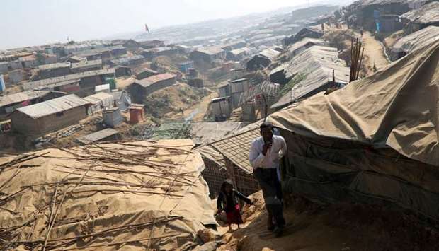Rohingya refugees walk along the Kutupalong refugee camp in Cox's Bazar, Bangladesh