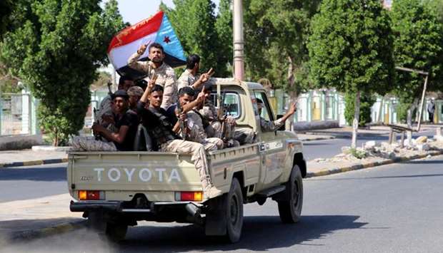 Southern Yemeni separatist fighters flash the V sign as they ride on the back of a truck in Aden yesterday. Reuters