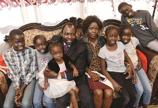 LOVEu2019S LABOUR WON: Physician assistant Jacob Ayuen and his wife Alakiir Deng sit with their six children at their Hanford home. Both Ayuen and Deng were Sudanese refugees during that countryu2019s civil war 30 years ago.