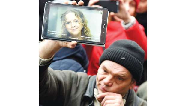 A man holds a tablet showing an image of Nozdrovska during a rally outside the Kiev police headquarters.