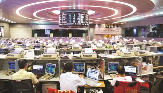 Traders work at the Hong Kong Stock Exchange. The Hang Seng closed up 0.2% to 30,560.95 points yesterday.