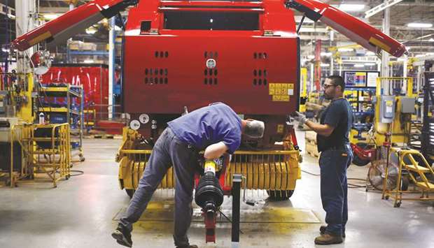 Workers review an assembled New Holland round baler at the companyu2019s Haytools factory in Pennsylvania (file). US factory activity increased more than expected in December, boosted by a surge in new orders growth, in a further sign of strong economic momentum at the end of 2017.