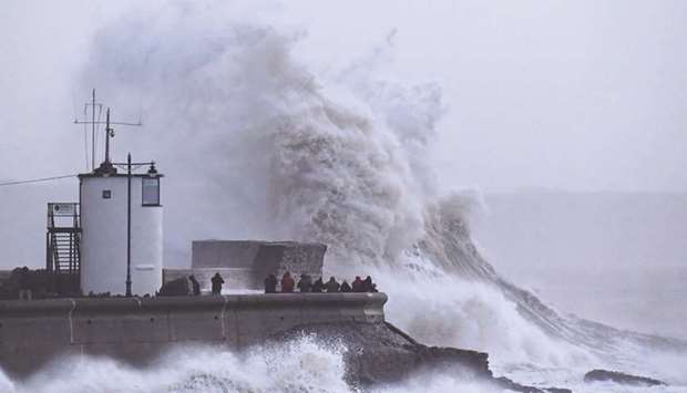 Large waves lash the lighthouse and seawall at Porthcawl in south Wales yesterday.