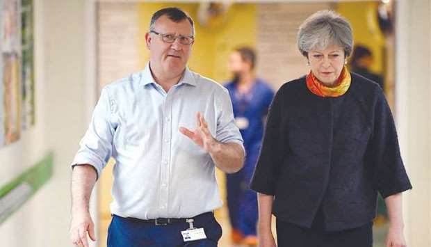 Prime Minister Theresa May speaks to Andrew Morris, CEO of Frimley Health Foundation Trust as she visits Frimley Park Hospital near Camberley yesterday.