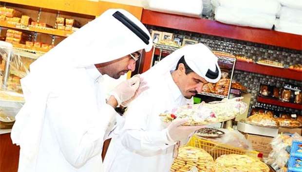 Inspectors examining food products at an outlet.