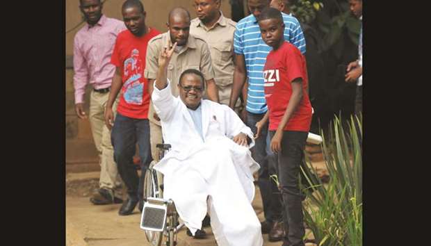 Tanzania Opposition lawmaker Tundu Lissu waves from his wheelchair after giving a press conference surrounded by members of his family and supporters yesterday at a hospital in Nairobi, to which he had been admitted since September 2017.