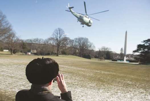 A man takes photographs as Marine One with President Trump on board departs from the South Lawn of the White House in Washington, DC as he travels for a weekend with Republican lawmakers at Camp David.