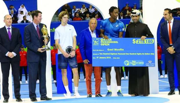 Gael Monfils receives the winner's cheque from Qatar Tennis Federation President Nasser bin Ghanim al-Kheleifi