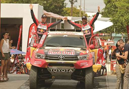 Toyota Gazoo team driver Nasser al-Attiyah of Qatar (right) and co-driver Matthieu Baumel of France on the podium during the departure ceremony of Dakar Rally 2018 in Lima, Peru, yesterday. (Reuters)
