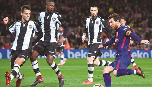 Barcelonau2019s Lionel Messi (right) shoots as Levanteu2019s Shaq Moore (centre) and Roberto Suarez Pier (left) look on at the Camp Nou stadium in Barcelona yesterday. (AFP)