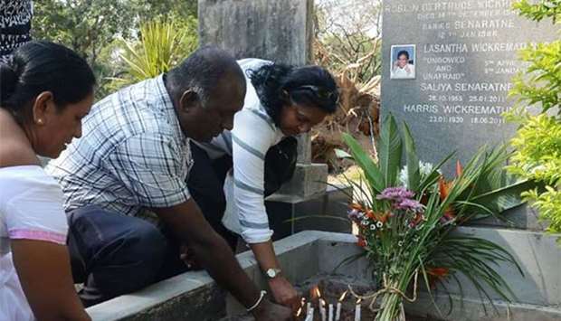 Sri Lankan mourners light candles at the grave of Lasantha Wickrematunga on the ninth anniversary of the editor's murder in Colombo on Monday.