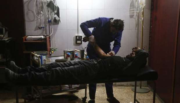 An injured Syrian man receives treatment at a makeshift hospital following reported air strikes in the rebel-controlled town of Madera, in the eastern Ghouta region on the outskirts of the capital Damascus.